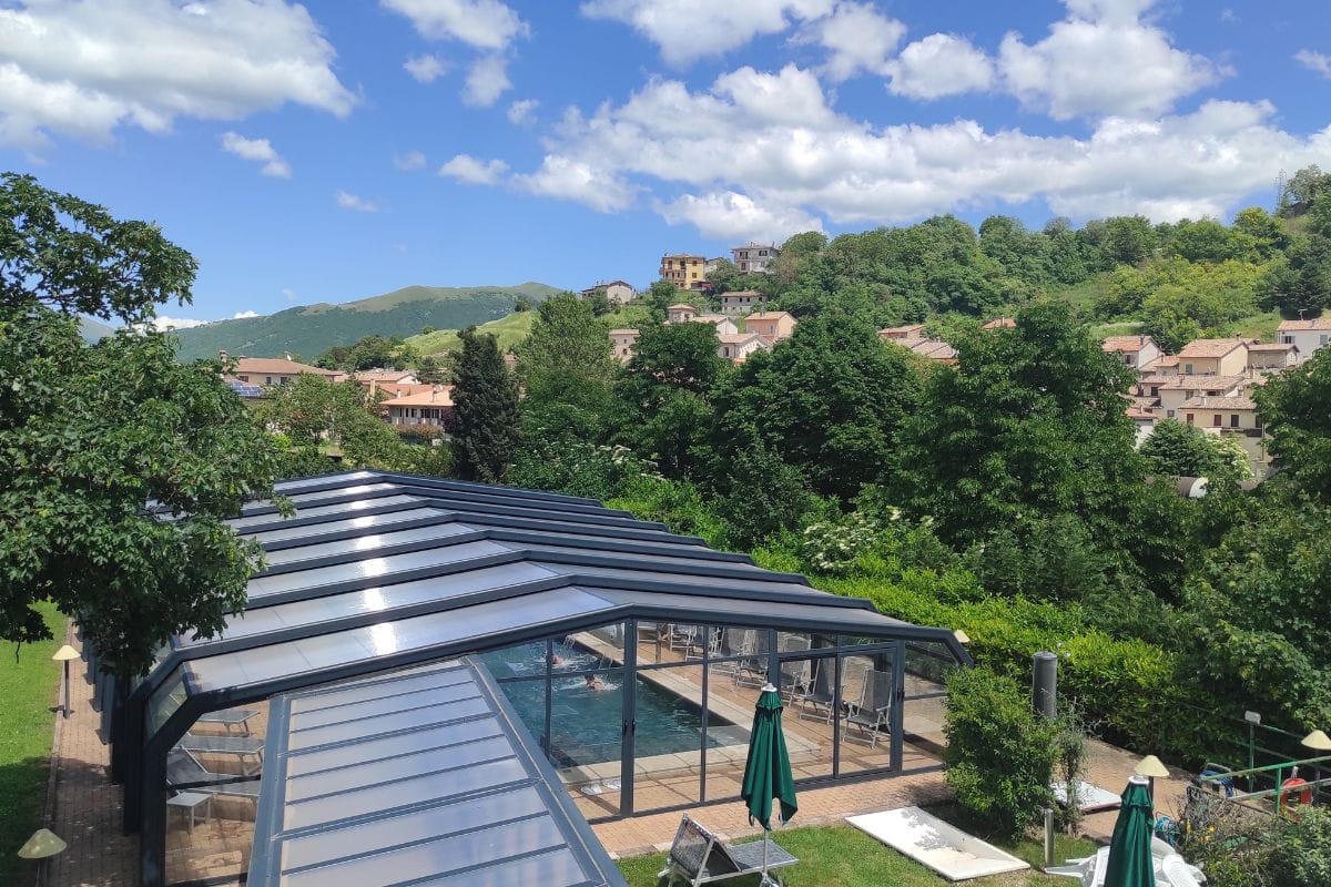 Piscina esterna dell'hotel Villa Fiorita coperta da settembre a giugno con vista su Colfiorito