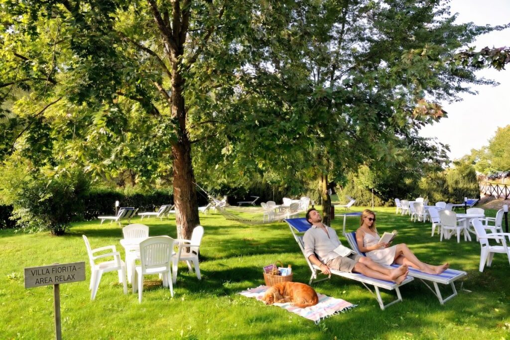 coppia con cane nel giardino dell'hotel benessere villa fiorita
